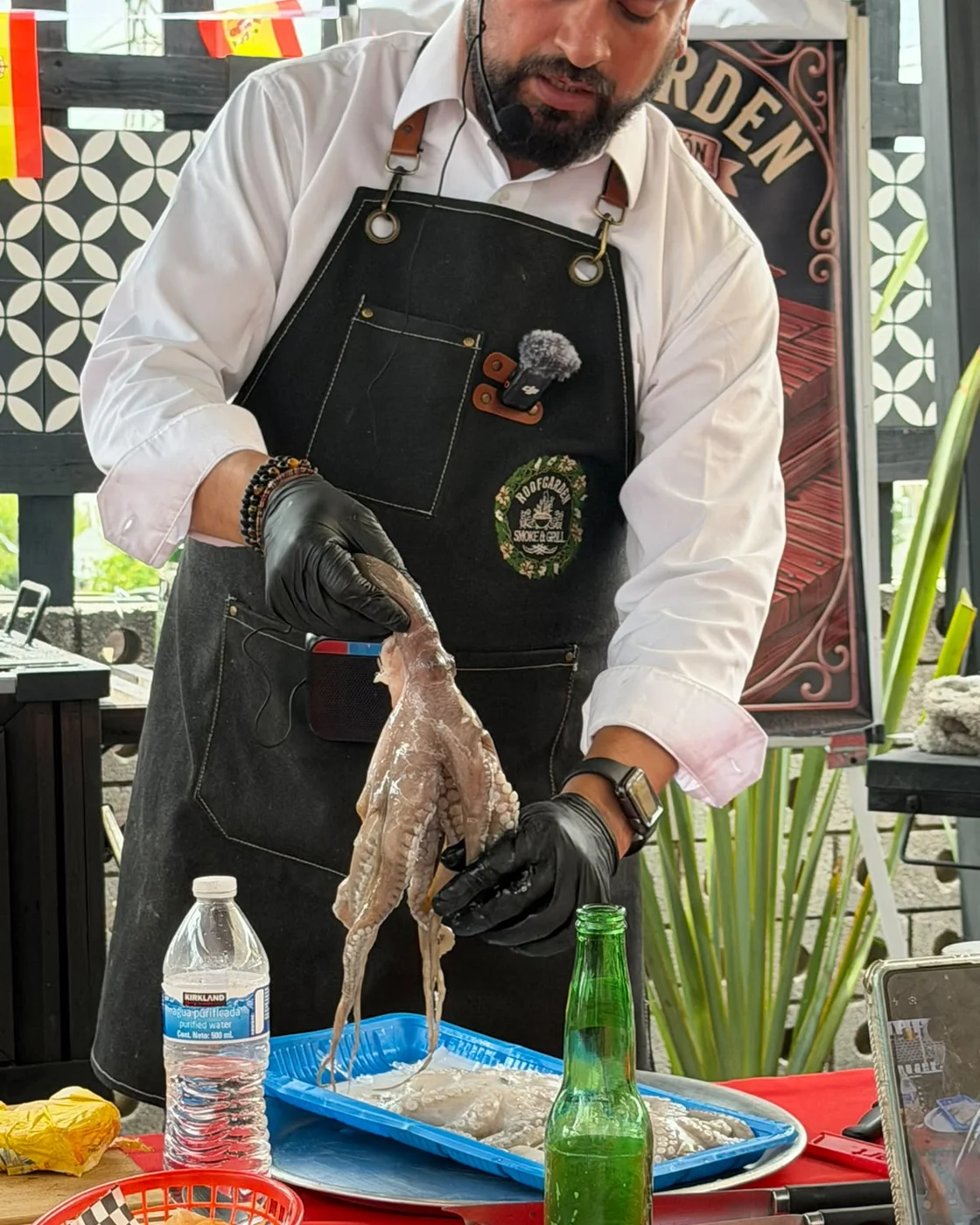 Chef de RoofGarden preparando pulpo fresco con técnica precisa antes de llevarlo a las brasas